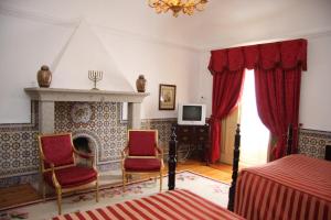 阿拉奥洛斯卡萨迪奥戈旅馆的一间卧室配有两把椅子和壁炉