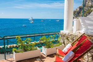 卡普里迪娃拉合族歌德尔马热酒店的俯瞰大海的阳台的长凳