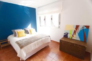 阿格特La Casa Del Valle的一间卧室设有一张床和蓝色的墙壁