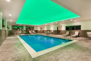 阿尔图纳Wingate by Wyndham Altoona Downtown/Medical Center的酒店大堂的游泳池,设有绿色天花板