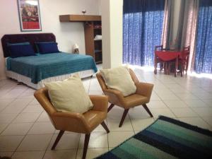 伊通比亚拉贝拉里约宾馆的一间卧室配有一张床、两把椅子和一张桌子