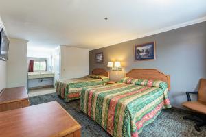 安纳海姆布埃纳维斯塔酒店的酒店客房设有两张床和一张桌子。
