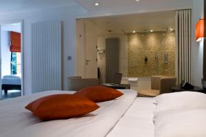 布尔沙伊德可库恩酒店的一间卧室配有带两个枕头的床和一间浴室