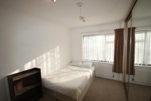 伦敦Hill Crescent的白色的客房配有床和电视。