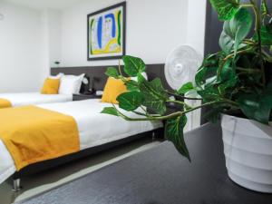亚美尼亚Hotel San Martin的一间卧室设有两张床和盆栽植物