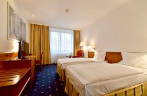 布拉格冠冕酒店的酒店客房配有两张床和一张书桌