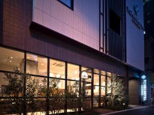 东京神田可可尼东正经济型酒店的夜间在建筑物前的商店