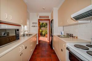 钓鱼镇Salop House的厨房配有白色橱柜和炉灶烤箱。