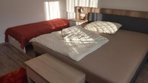 KlingenbachFerienhaus Karall的客房设有两张床和一张带床垫的桌子。