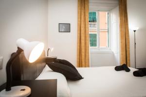 热那亚Leone X Genova Affittacamere的一间卧室配有一张带灯和窗户的床
