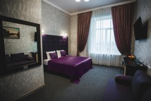 伊兹梅尔Отель БЕССАРАБИЯ的酒店客房配有紫色的床和镜子