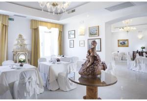 布林迪西阿尔伯格国际大酒店的用餐室配有白色的桌子和白色的椅子