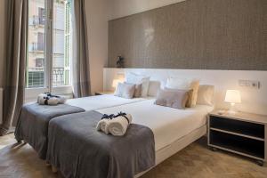 巴塞罗那花园景人居公寓的两张位于酒店客房的床,配有毛巾