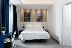 托里德欧索贝尔韦德雷酒店的卧室配有白色的床,墙上挂有两幅画作