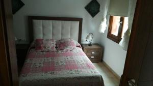 蒂亚斯Paraiso Rubicón的一间卧室配有一张带粉色毯子和镜子的床
