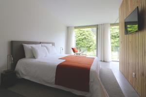 富尔纳斯World's Nests Furnas Pods Village的一间卧室设有一张大床和一个大窗户