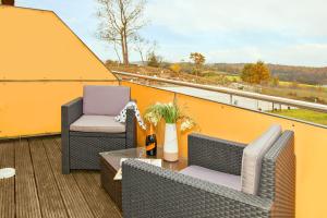 赛巴特班森Hotel Bergmühle的阳台配有两把椅子和一张桌子,位于屋顶