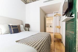 里斯本Luxury T.M. Flat With a View的卧室配有白色的床和绿门