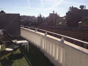 图卢兹奥尔斯布兰科酒店的一张长凳,坐在俯瞰着城市的阳台