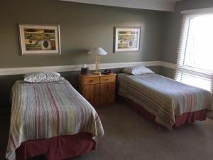 萨斯卡通劳拉小屋宾馆的一间卧室设有两张床、一盏灯和一扇窗户。