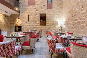 洛格罗尼奥Eurostars Fuerte Ruavieja的一间带桌椅和石墙的餐厅
