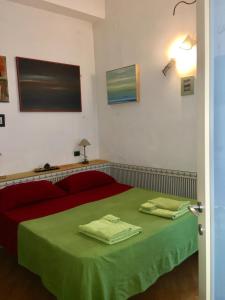 那不勒斯切尔托萨岛公寓的一间卧室配有红色的床和绿色床单