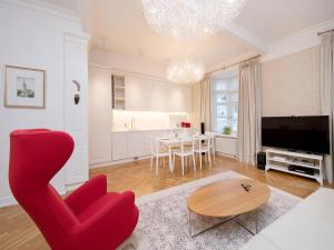 塔林哈留老城公寓的客厅配有红色椅子和桌子