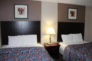 梅普尔格罗夫Coratel Inn and Suites Maple Grove的酒店客房,设有两张床和一盏灯