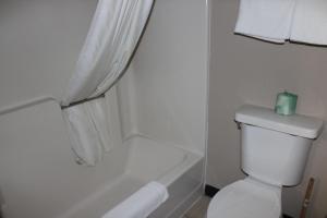 梅普尔格罗夫Coratel Inn and Suites Maple Grove的浴室设有卫生间和浴缸,浴缸上装有蜡烛