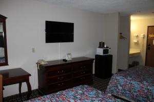 梅普尔格罗夫Coratel Inn and Suites Maple Grove的酒店客房设有两张床、一个梳妆台和电视。