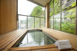 草津Kusatsu Hotel Bekkan Wata no Yu (Adult Only)的一座带大窗户的房屋内的游泳池