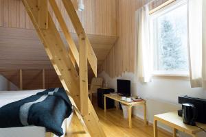 罗瓦涅米沃特萨拉极光岛酒店的一间卧室设有一张床和木制楼梯。