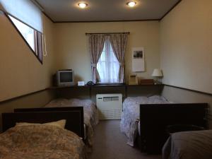 茅野四季之宿宾馆的一间卧室设有两张床和窗户。