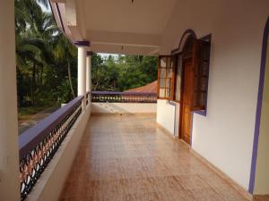 卡乌罗西姆Lobo's Guesthouse的走廊,房子的门和阳台