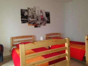拉戈斯拉各斯市中心旅馆的一间卧室配有两张双层床,铺有红色床单