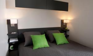 法沃内维尼奇度假屋的一间客房,床上配有两个绿色枕头