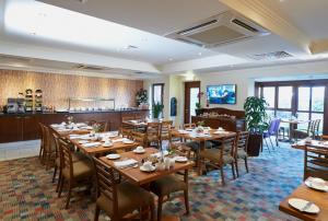 德比摩尔莉哈耶斯酒店的一间带木桌椅的餐厅和一间酒吧
