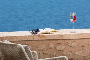 莫奈姆瓦夏莫尼艾姆瓦西斯奢华套房酒店的一杯葡萄酒,墙上的书和饮料