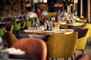 里德凯尔克凡德瓦克酒店的配有桌椅和酒杯的餐厅
