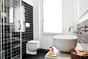 博洛尼亚穆亚酒店的带浴缸、卫生间和盥洗盆的浴室
