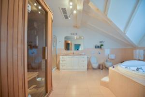 洛夫兰洛夫兰纳德拉格酒店的浴室设有2个卫生间、水槽和浴缸。