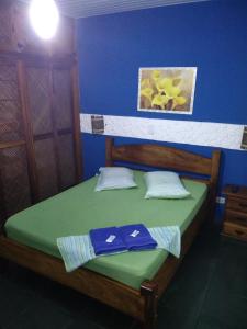 卡拉瓜塔图巴绿色海岸宾馆的一间卧室配有一张绿色的床和蓝色的墙壁