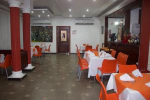 SabanetaGran Hotel Marien的一间设有桌椅和红色柱子的用餐室