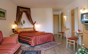 费拉迪普利米罗萨斯玛尔酒店的一间卧室配有一张床、一张沙发和一台电视。