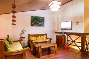 塞古罗港Alto do Aeroporto Hotel的客厅配有木制家具和平面电视