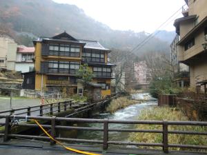 会津若松东山温泉元汤有马屋日式旅馆的河边建筑物前的河流