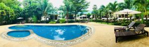 高兰N.T.蓝塔度假酒店的度假村内的游泳池,配有两把椅子和一把遮阳伞