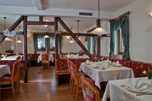 鲁多尔施塔特爱特姆全景酒店及餐厅 的一间设有白色桌椅的用餐室