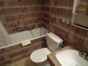 韦尔比耶Apartment Mandarin 118Bis的浴室配有卫生间、浴缸和水槽。