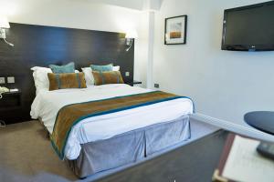 赫克瑟姆赫克瑟姆博蒙特酒店的一间卧室配有一张大床和一台平面电视